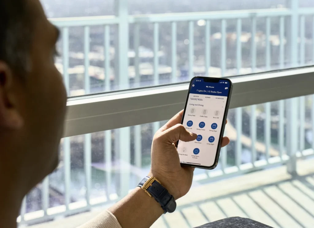 homeowner operating motorized drapes and smart lighting scenes via mobile app control interface